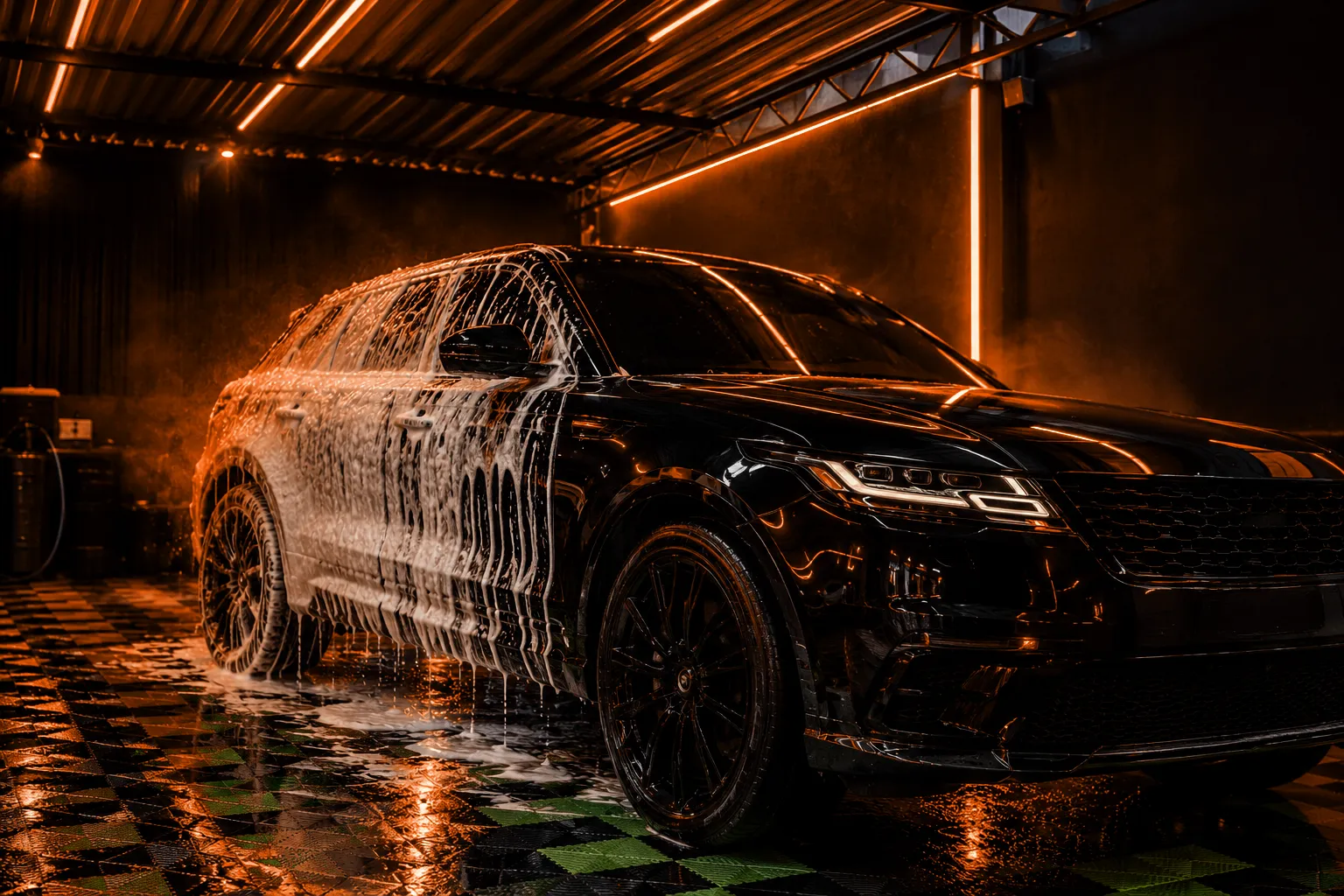 SUV preto coberto de espuma na área coberta da Imperium Black, com luz laranja